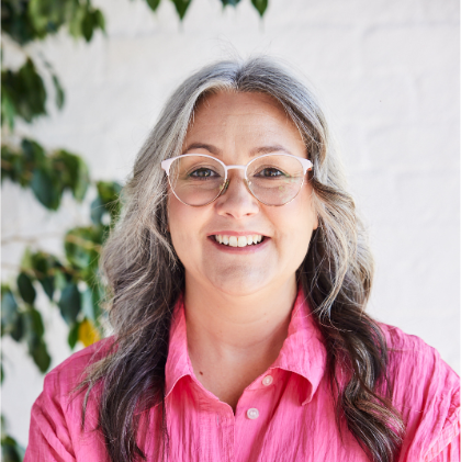 woman with glasses and pink shirt and smiling